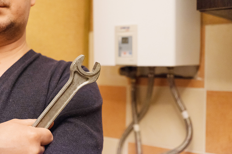 male hand holding a wrench on the background gas heater. concept